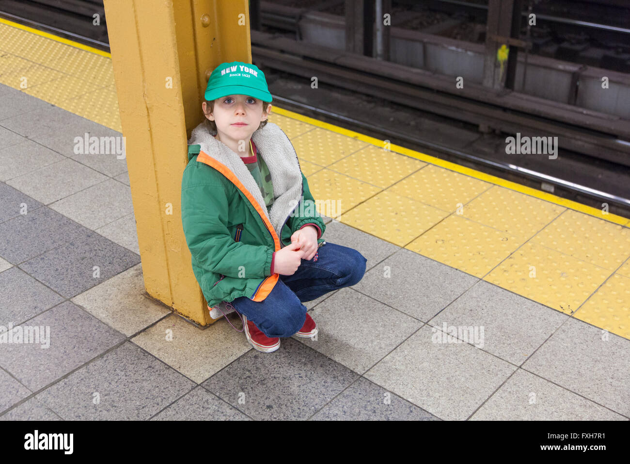 Un garçon de six ans sur la plate-forme de Pennsylvanie Métro Station 34th Street, New York City, États-Unis d'Amérique. Banque D'Images