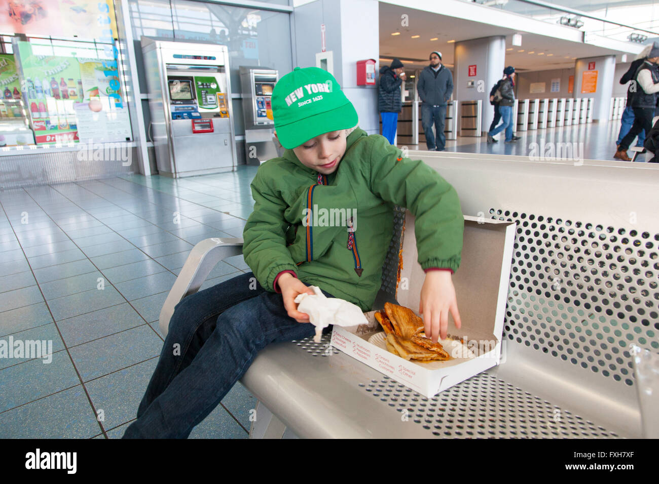 Six ans boy eating pizza fraîche, Staten Island Ferry Terminal, Staten Island, New York, États-Unis d'Amérique. Banque D'Images