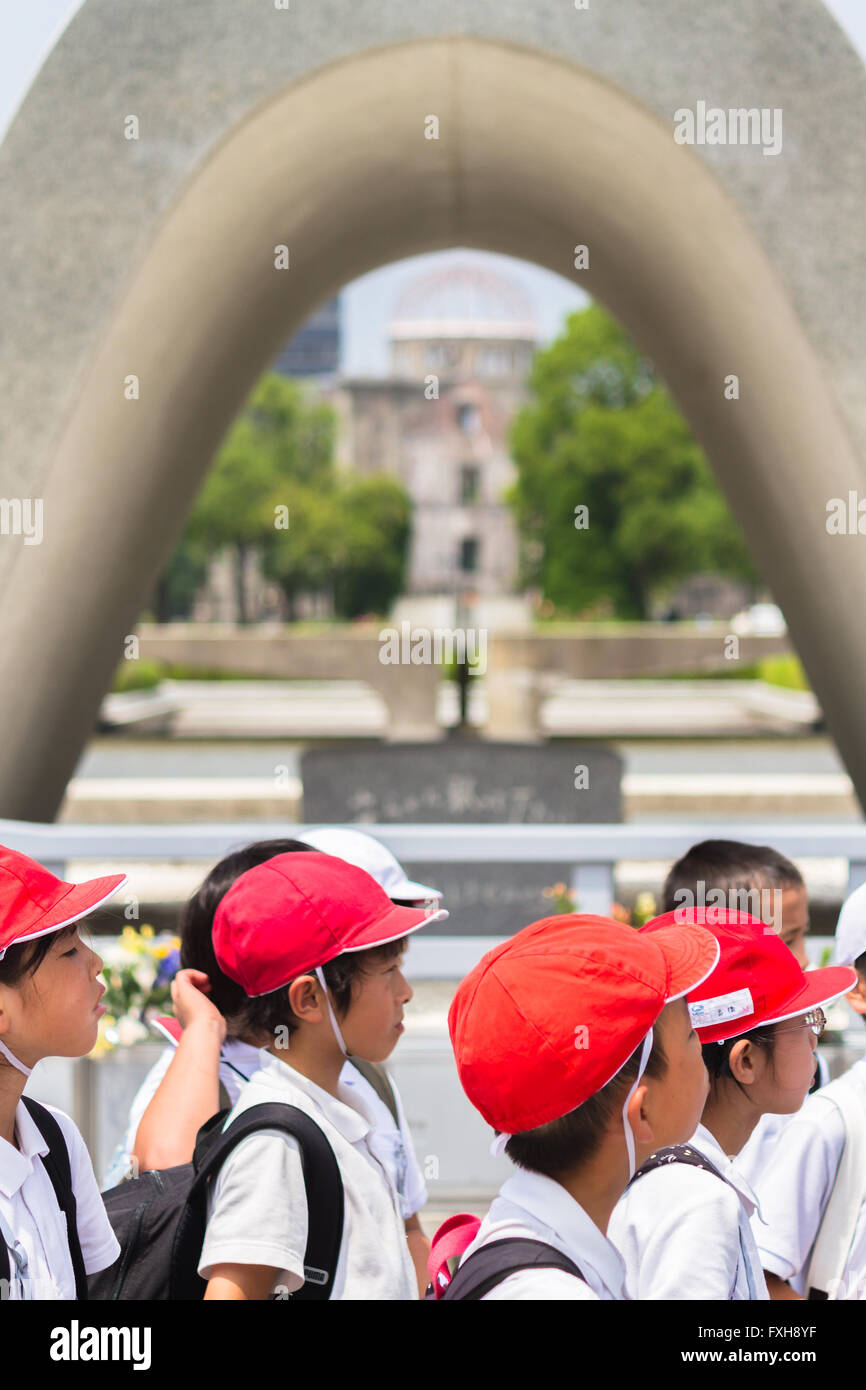 Les enfants de l'école japonaise visiter le monument cénotaphe dans le centre de Hiroshima Peace Memorial Park Banque D'Images