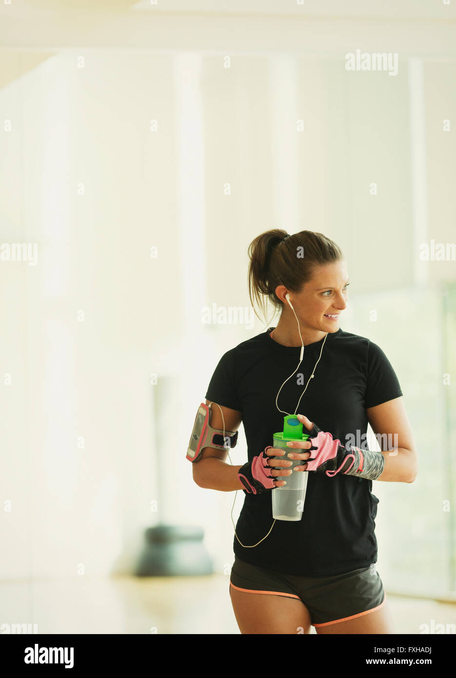Smiling woman drinking water in gym studio Banque D'Images