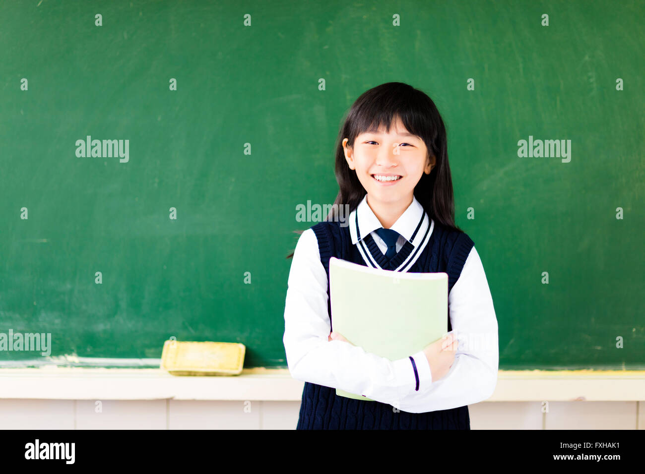 Happy student girl with book in classroom Banque D'Images