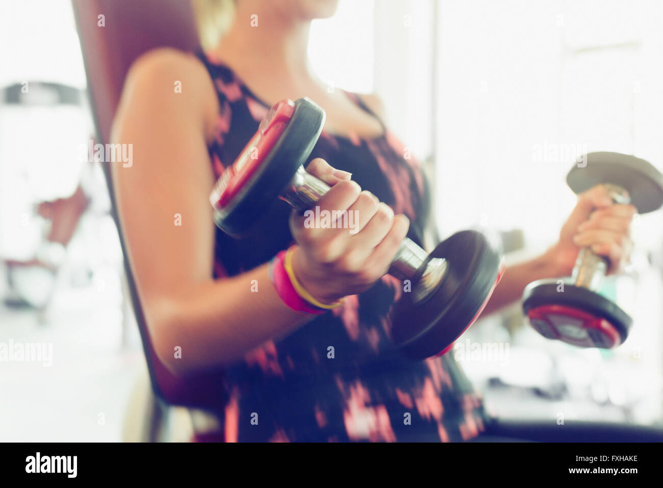 Blurred motion faisant haltère biceps at gym Banque D'Images