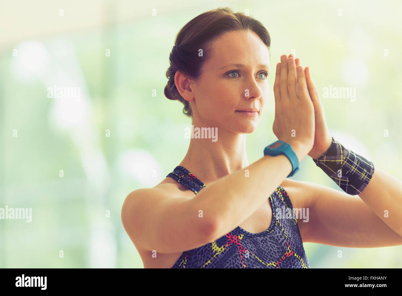 Femme calme avec mains en position de prière dans la classe de yoga Banque D'Images