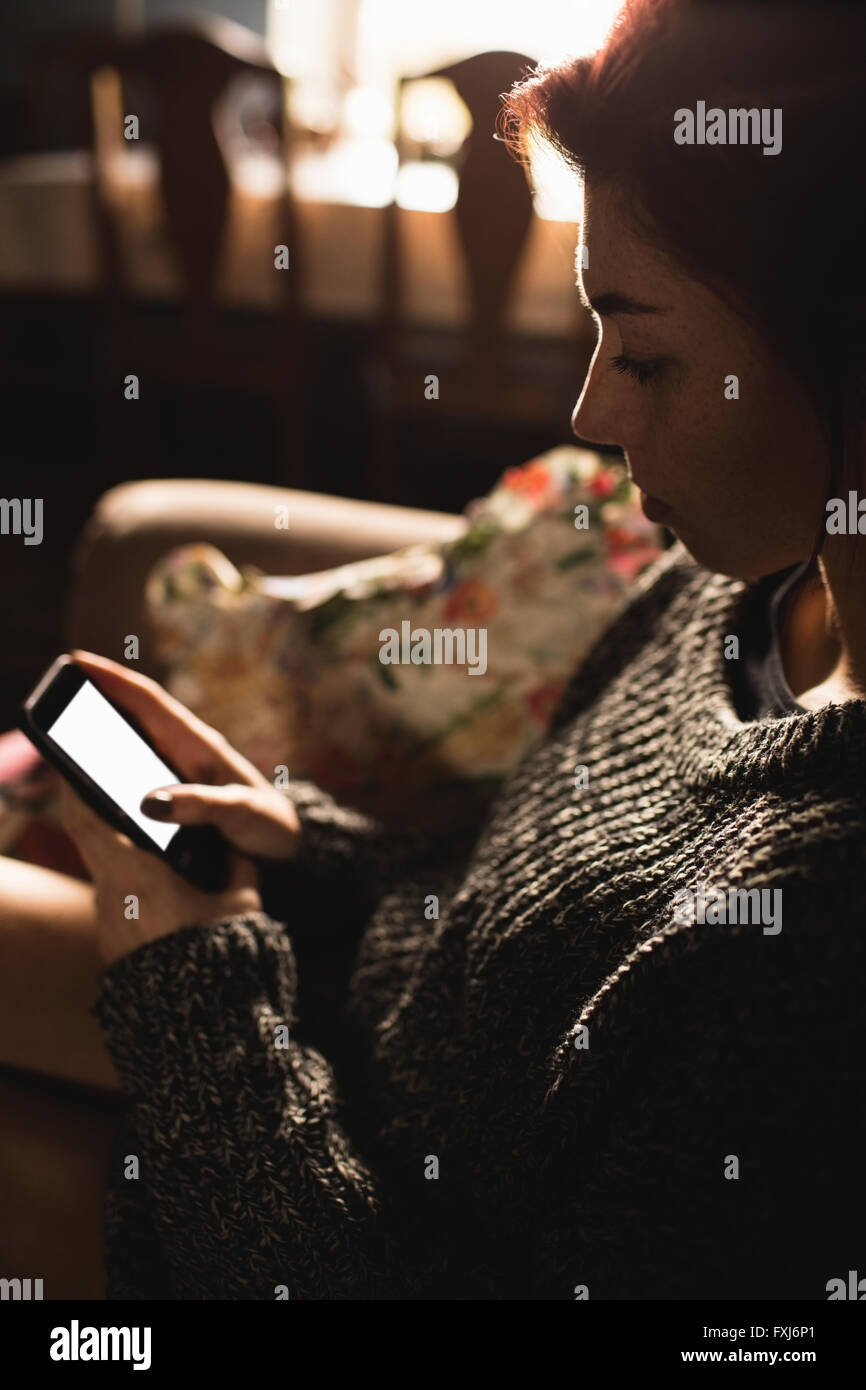 Young woman text messaging on mobile phone Banque D'Images