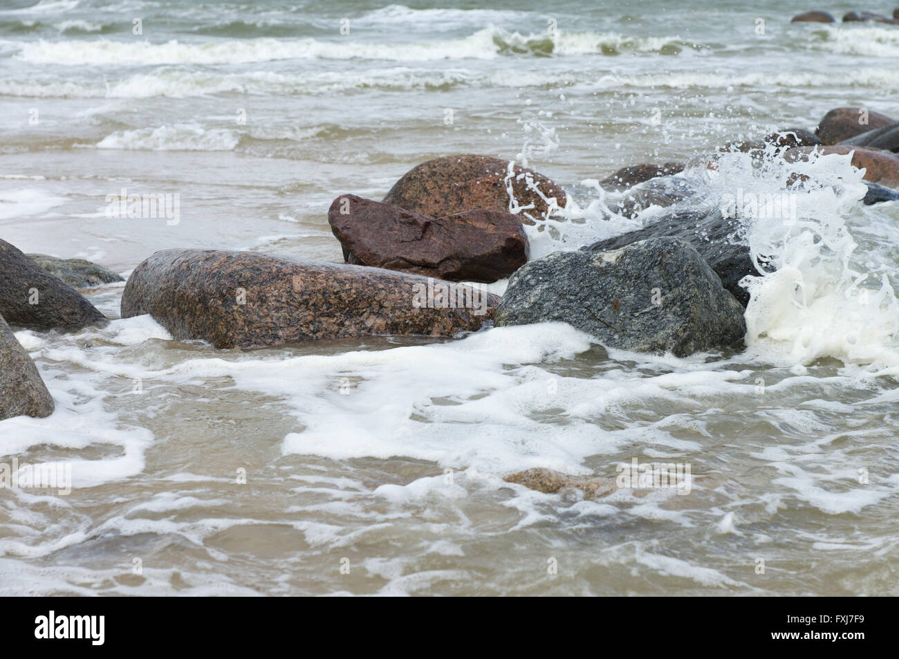 Des pierres se trouvent dans une mer déchaînée sous les coups de grosses vagues Banque D'Images