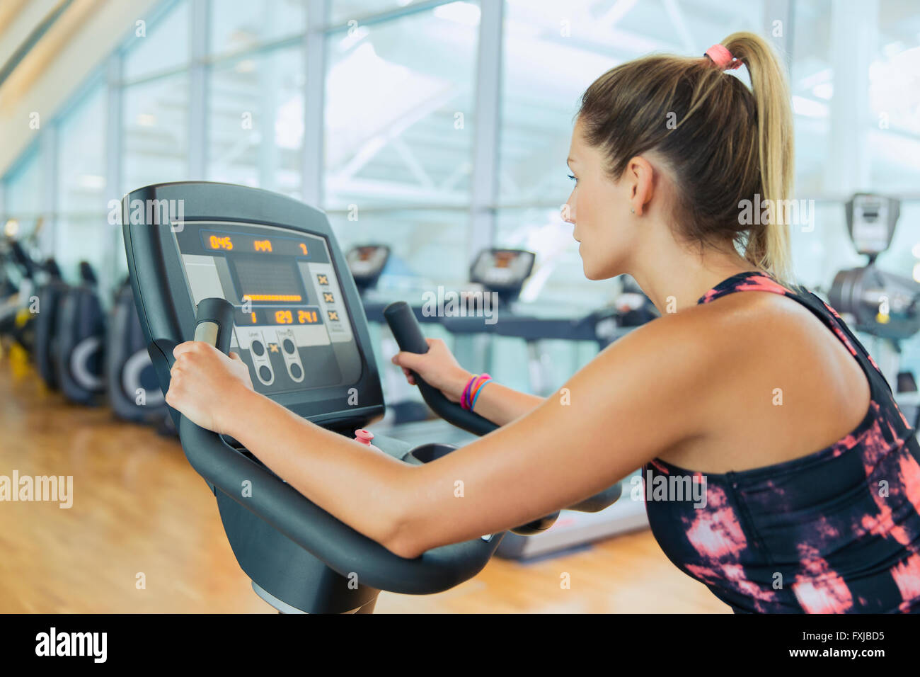 Woman riding exercise bike at gym Banque D'Images