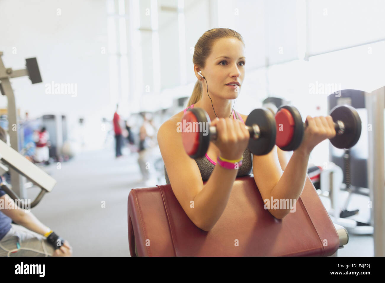 Femme de biceps haltère at gym Banque D'Images