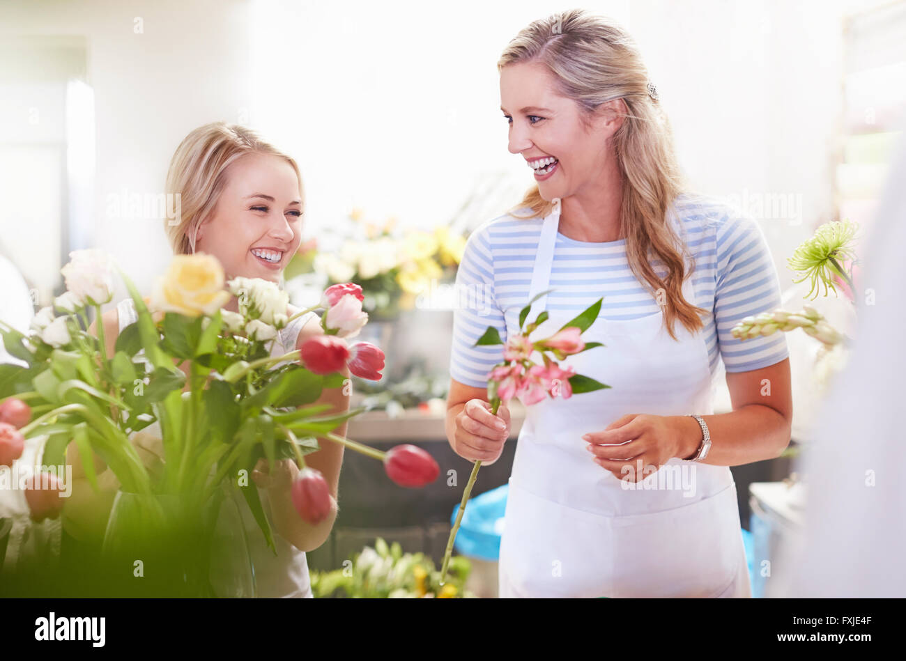 Les fleuristes de rire dans le magasin de fleurs bouquet organisation Banque D'Images