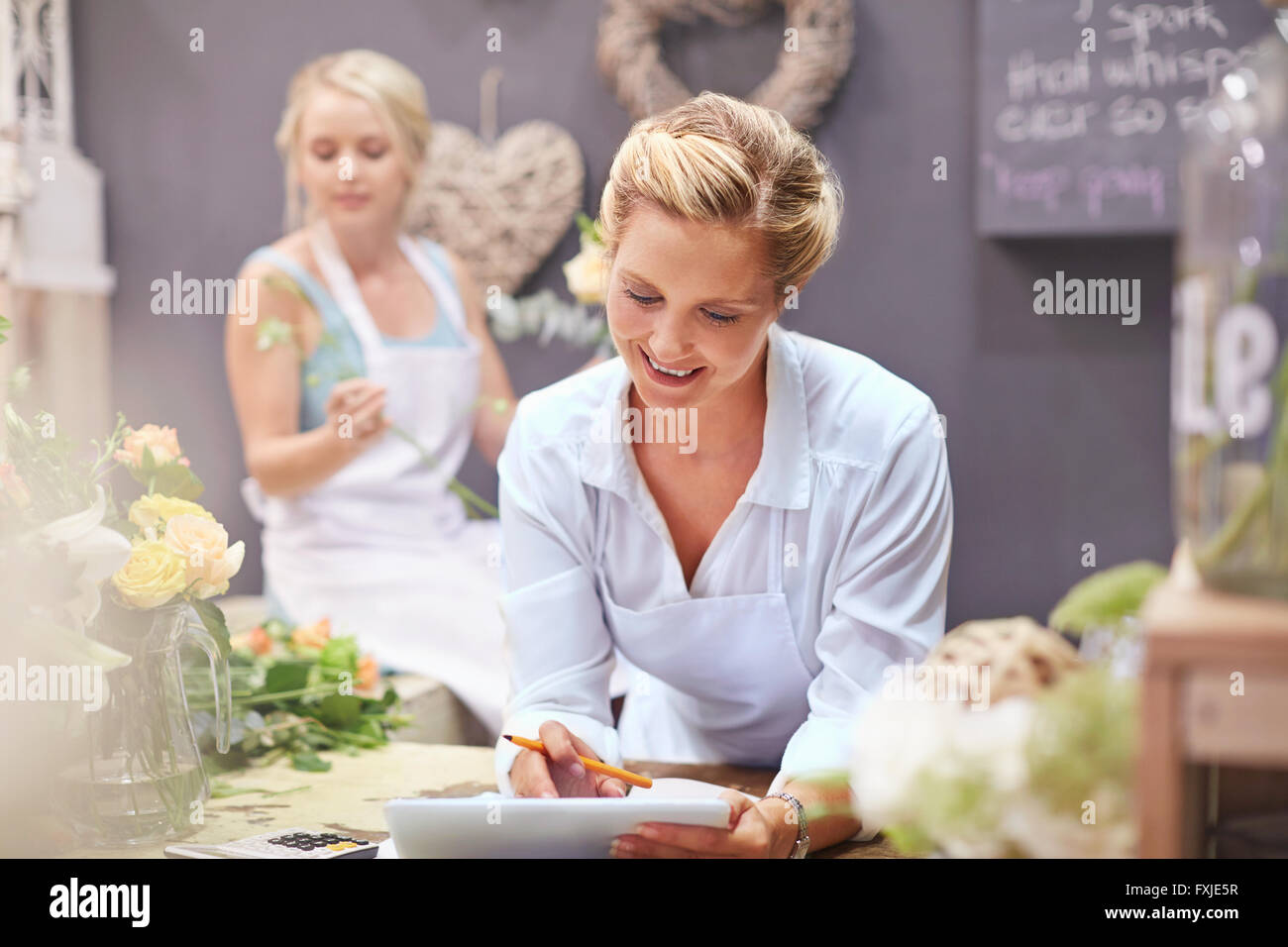 Florist using digital tablet in flower shop Banque D'Images