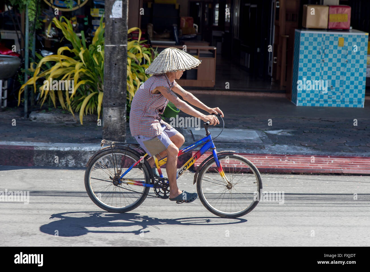 Man in hat rouler à vélo dans les rues de la ville Banque D'Images