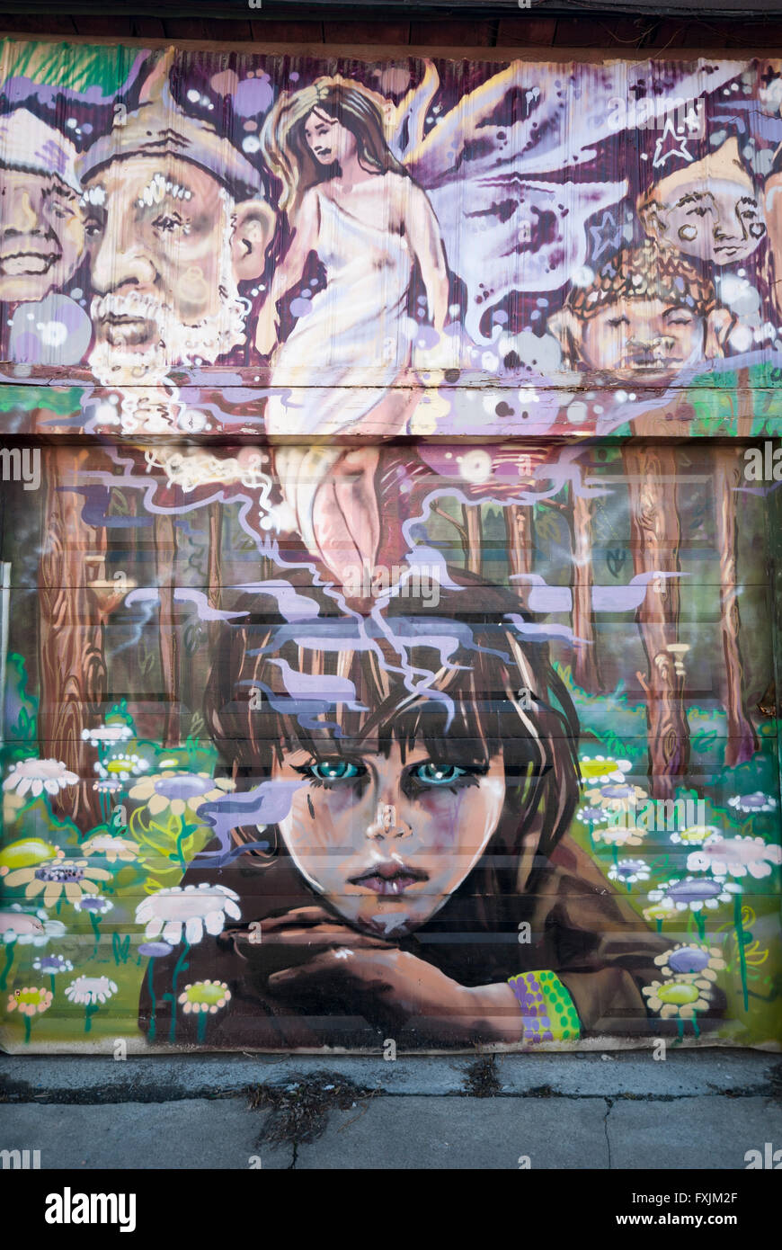 Toronto, Canada. Un graffiti créatif portrait d'une jeune fille peint sur une ruelle porte de garage à Kensington Market. Banque D'Images