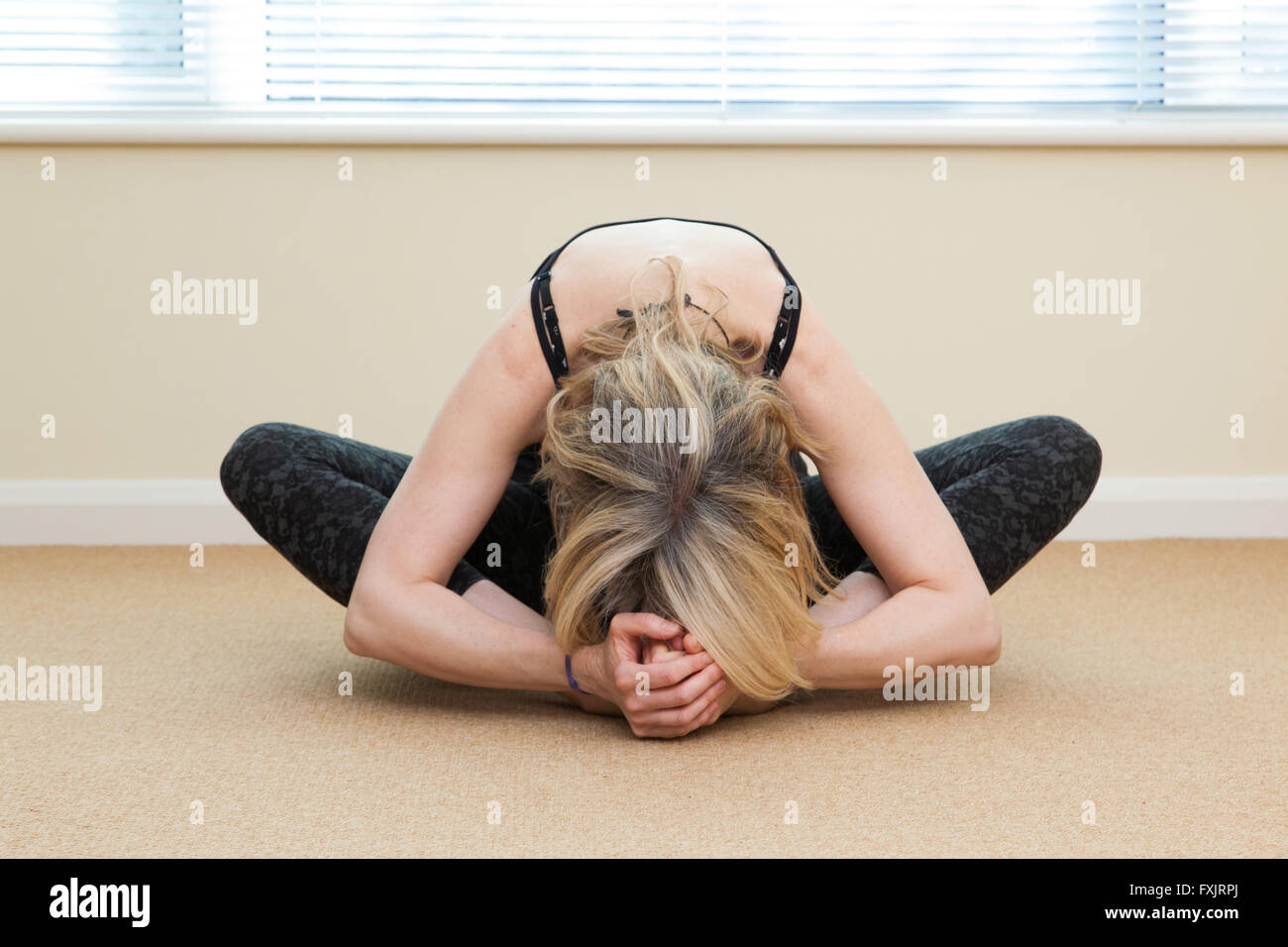 Une femme dans une pose de yoga indoors Banque D'Images