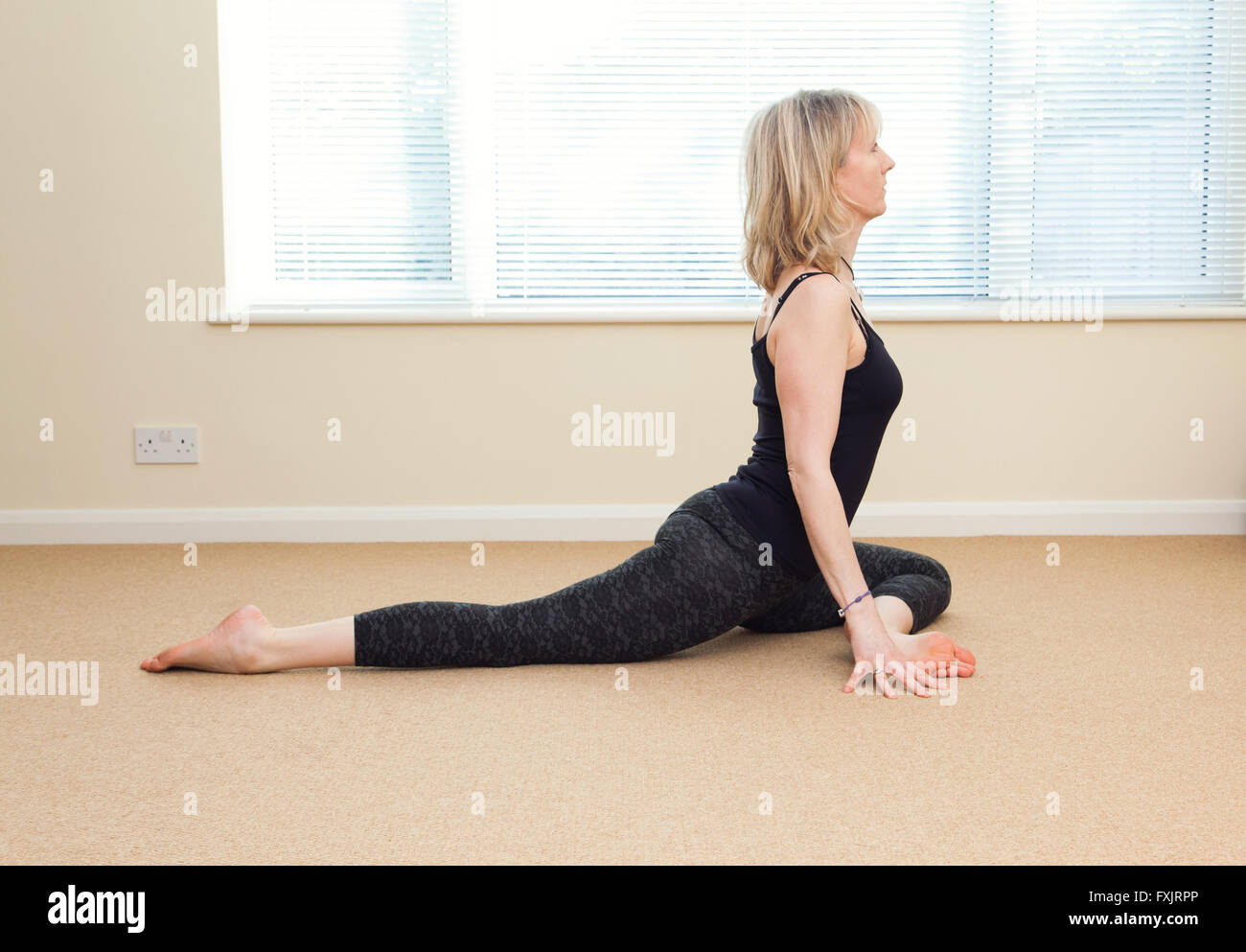 Une femme dans une pose de yoga indoors Banque D'Images