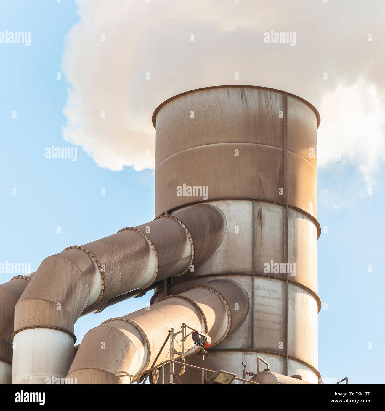Vieille cheminée industrielle émis de la fumée blanche Banque D'Images