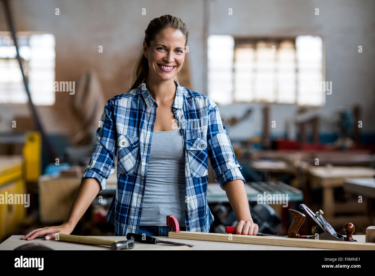 Portrait of female carpenter debout avec l'outil de travail Banque D'Images