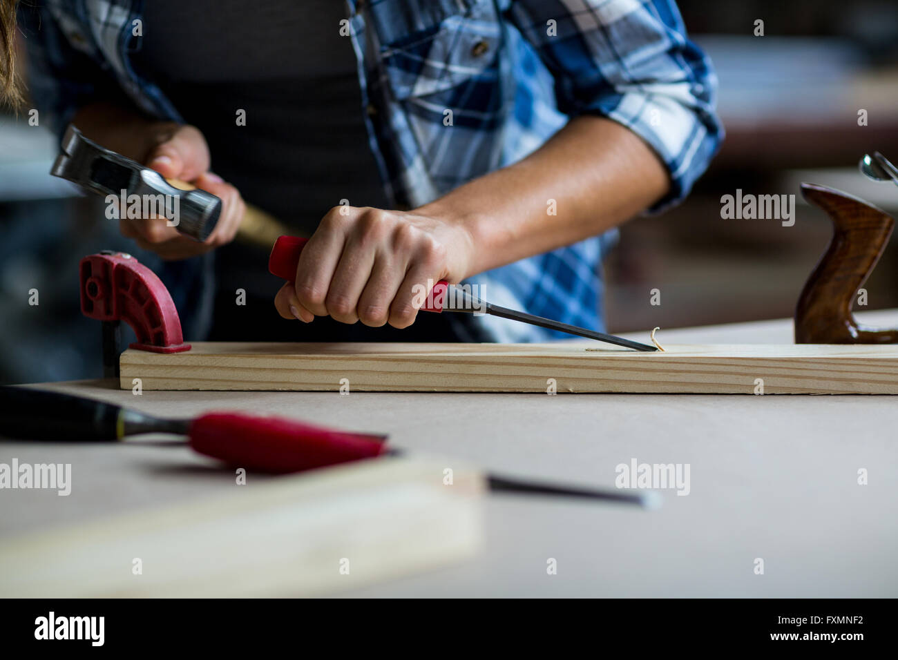 Female Carpenter à l'aide d'un burin sur planche en bois Banque D'Images