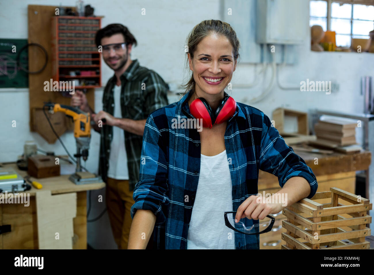 Homme et femme carpenter smiling in workshop Banque D'Images