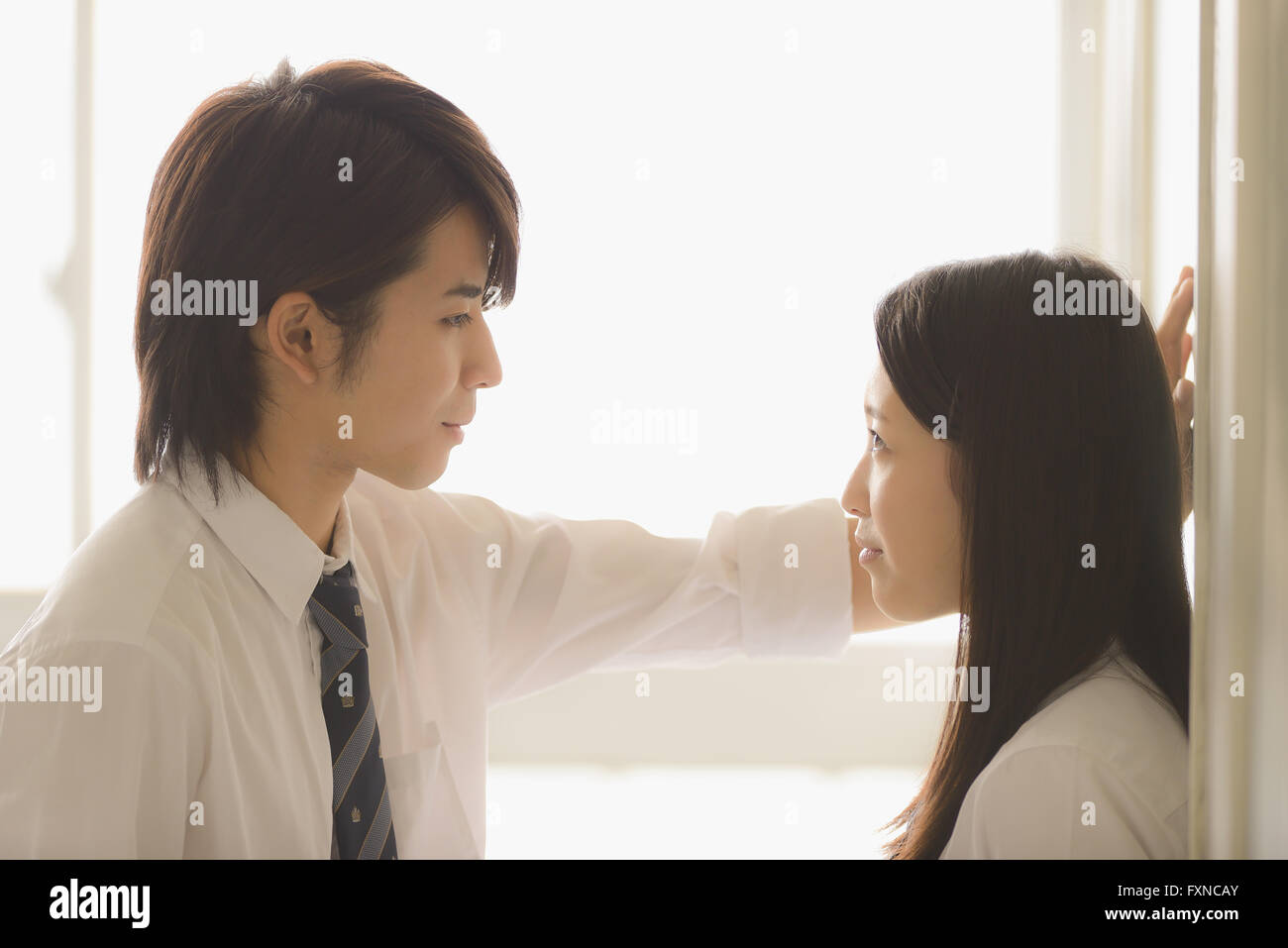 Les lycéens japonais dans un moment romantique dans le couloir d'école Banque D'Images