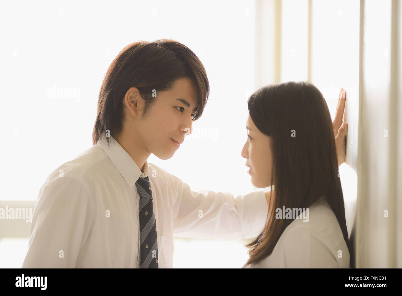 Les lycéens japonais dans un moment romantique dans le couloir d'école Banque D'Images