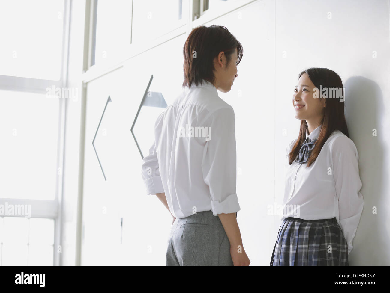 Les lycéens japonais dans un moment romantique dans le couloir d'école Banque D'Images