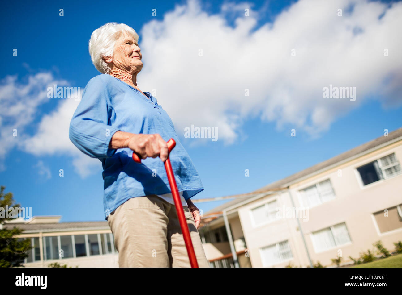 A senior woman walking avec son bâton de marche Banque D'Images