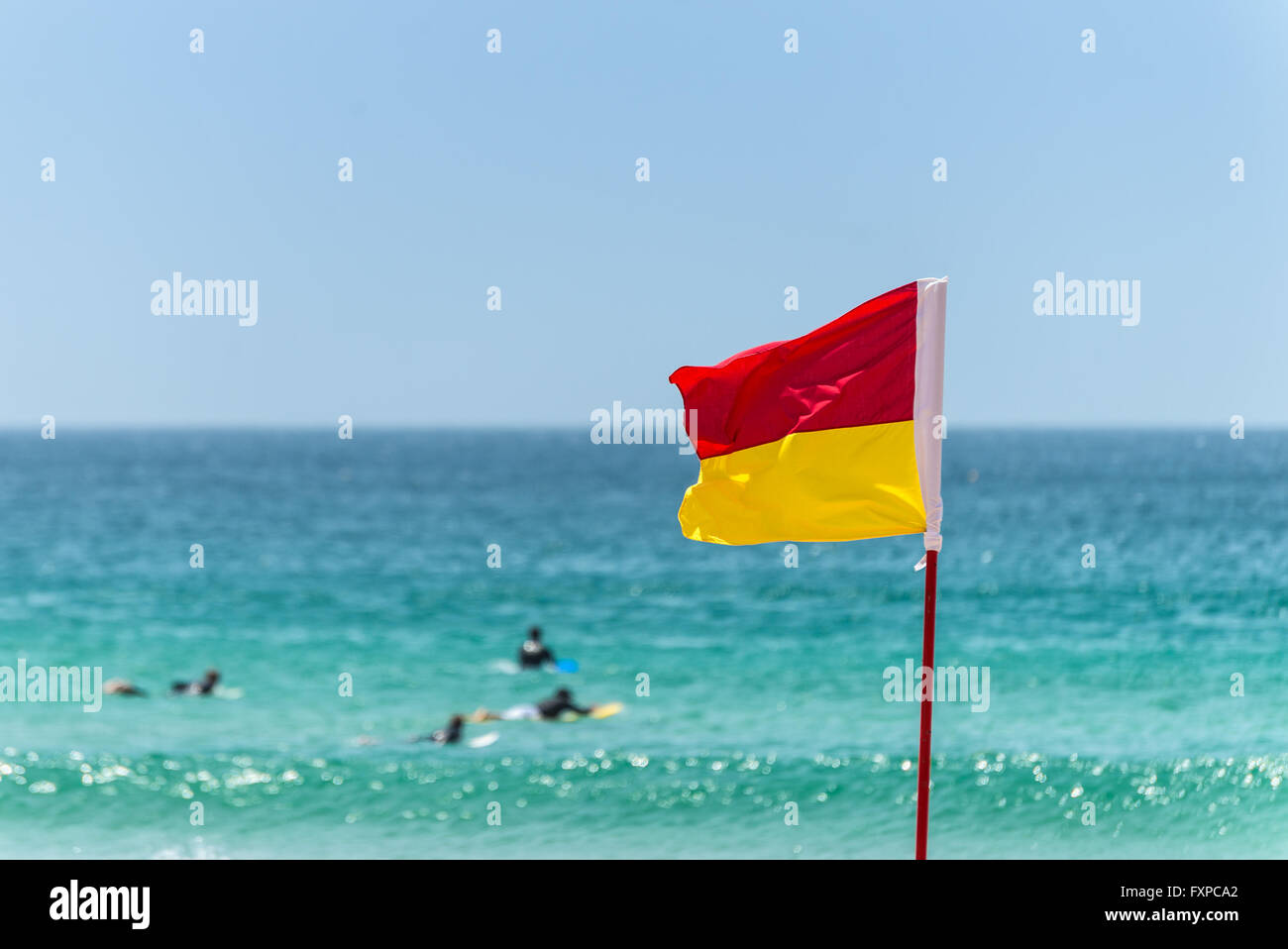 Drapeau rouge et jaune marquant la limite de la zone de baignade en toute sécurité sur une plage sous un ciel d'été bleu Banque D'Images Drapeau rouge et jaune marquant la limite de la zone de baignade en toute sécurité sur une plage sous un ciel d'été bleu Banque D'Images