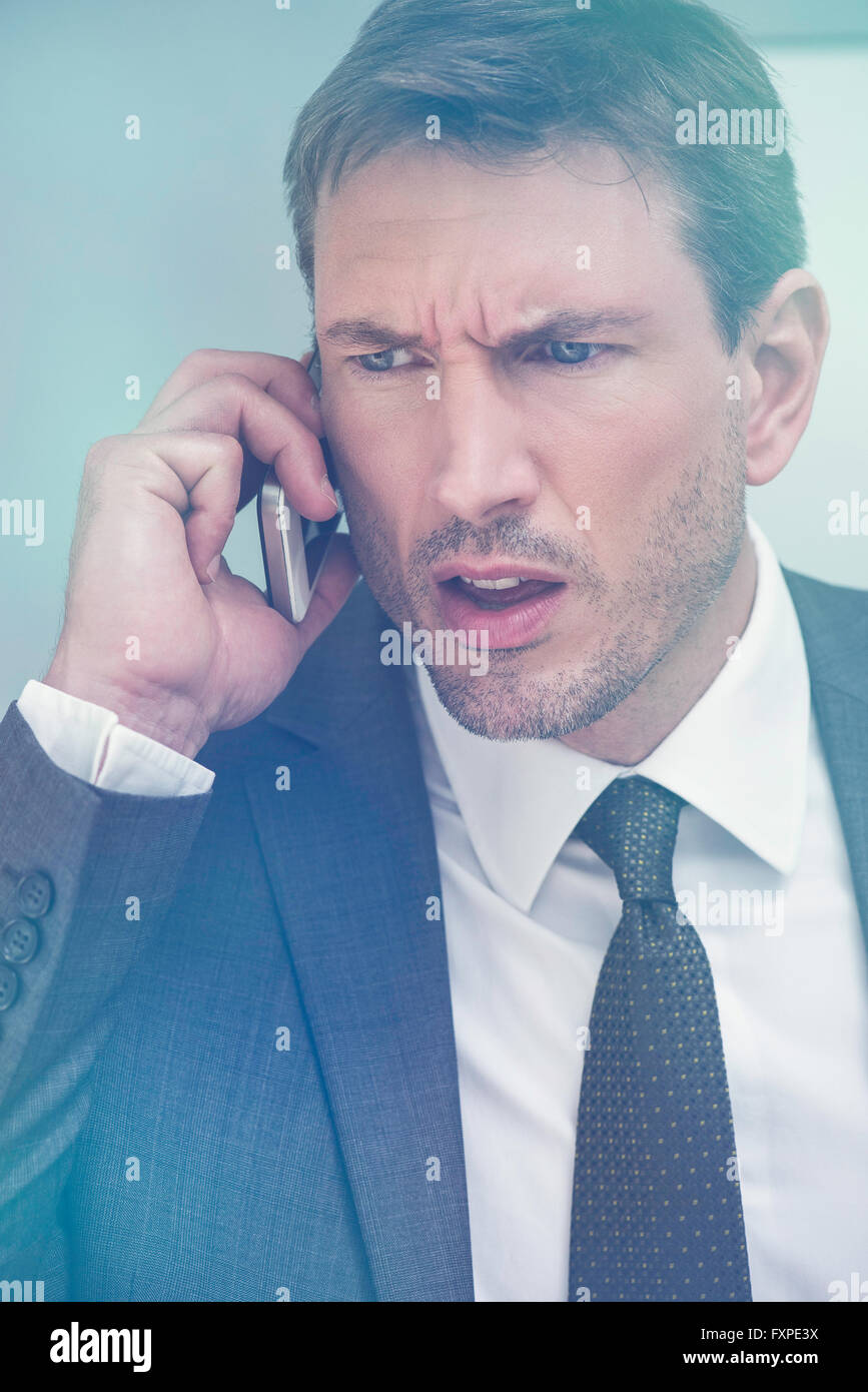 Businessman recevoir de mauvaises nouvelles par téléphone cellulaire Banque D'Images