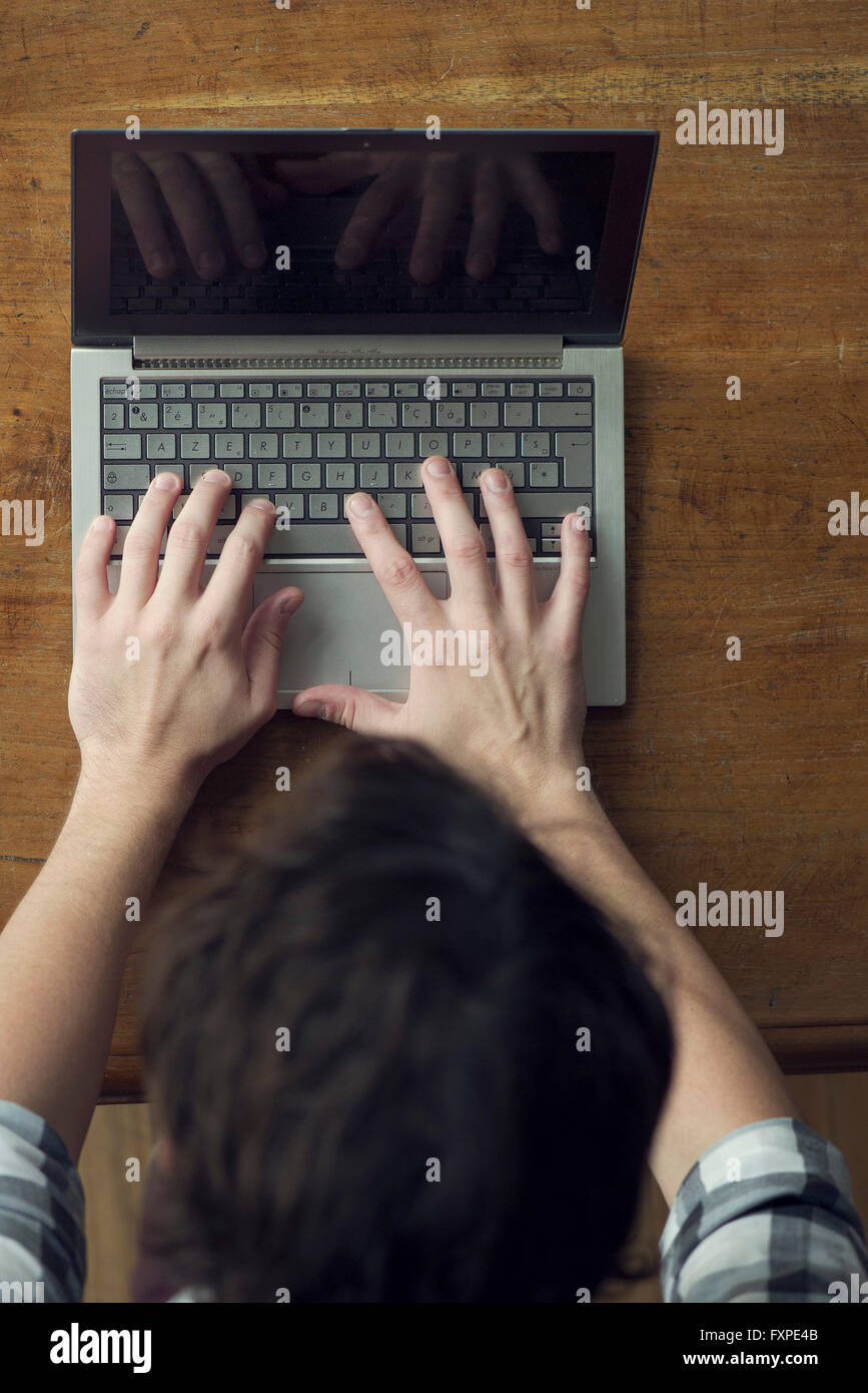 Man typing on laptop computer furieusement Banque D'Images