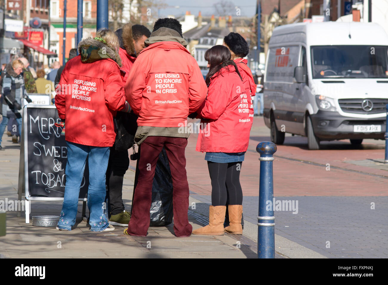 Groupe de collectionneurs de bienfaisance groupe recroquevillé dans un moment ennuyeux le public à Hitchin, Hertfordshire, Angleterre Banque D'Images