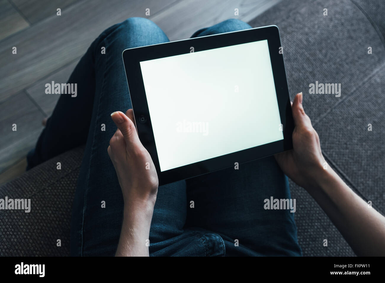 Femme et tablet on sofa at home Banque D'Images