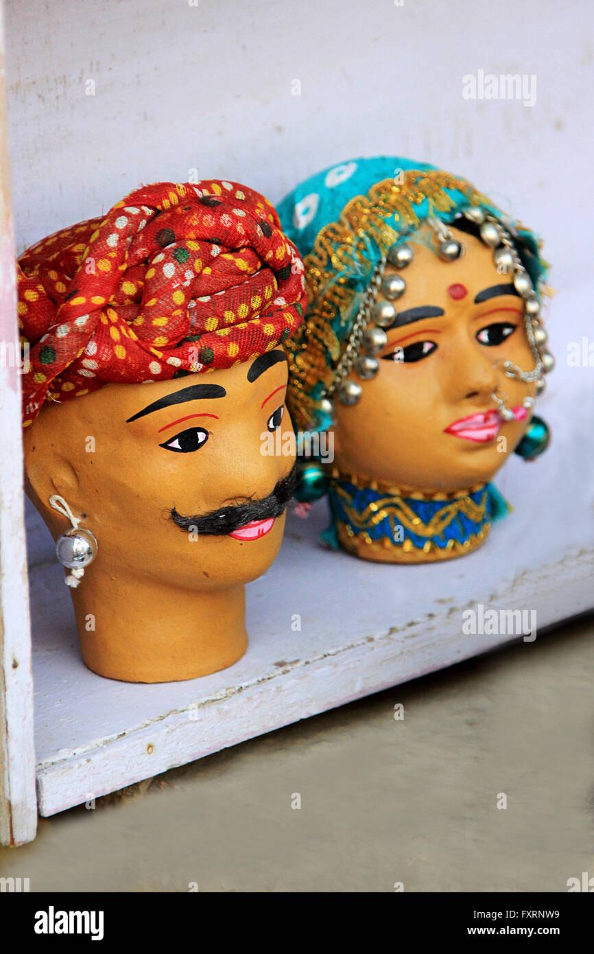Visages de terre cuite colorée couple Rajasthani drapés dans des costumes traditionnels sur l'affichage à l'Gadisar Lake, Jaisalmer, Rajasthan, en Banque D'Images