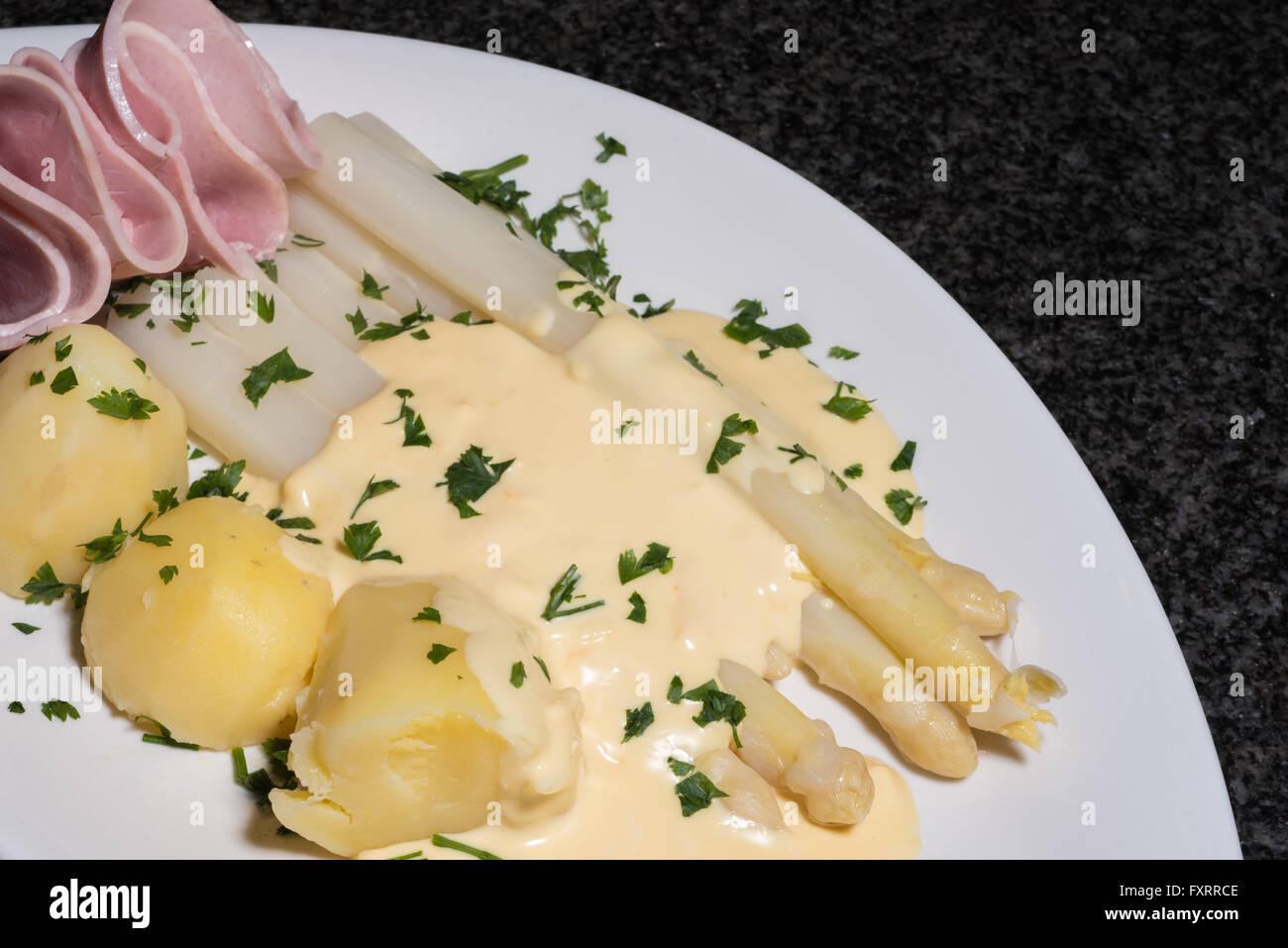 Les asperges blanches cuites avec des pommes de terre, jambon et parslay Banque D'Images