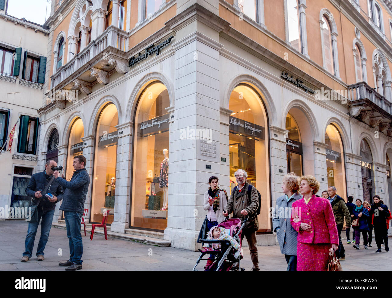 Les italiens de Venise les habitants et les touristes de shopping. Homme poussant poussette de bébé en face de Ferragamo et Gucci boutiques de mode. Banque D'Images