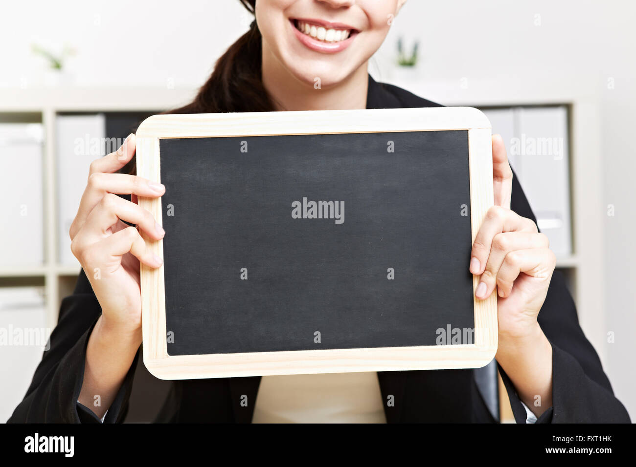 Happy business woman holding petit tableau noir Banque D'Images