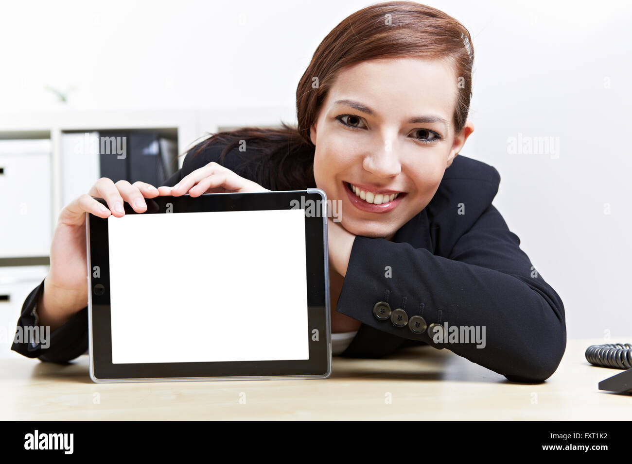 Happy business woman dans son bureau la présentation d'un tablet computer Banque D'Images