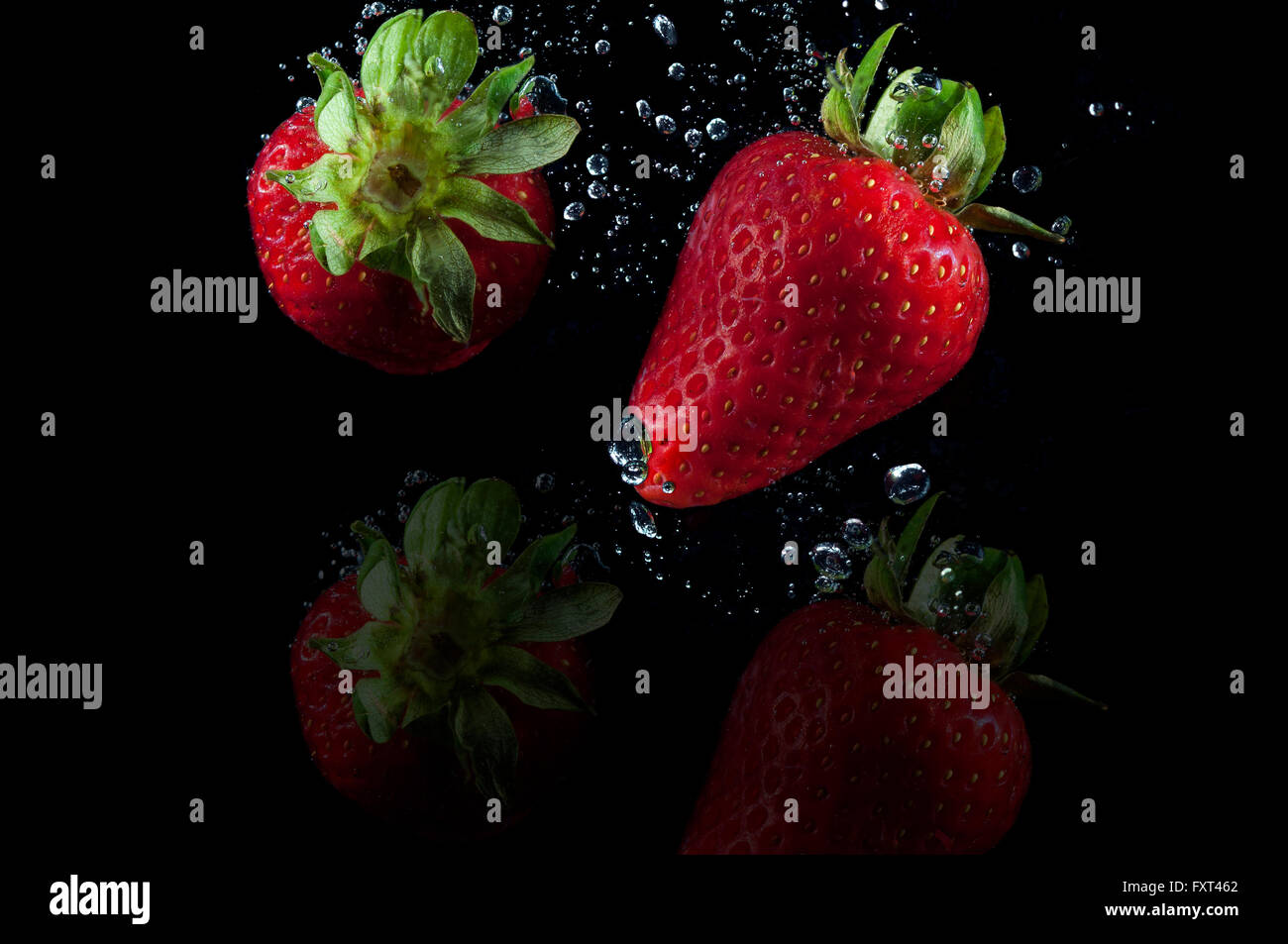 Les fraises splash et bulles d'eau Banque D'Images
