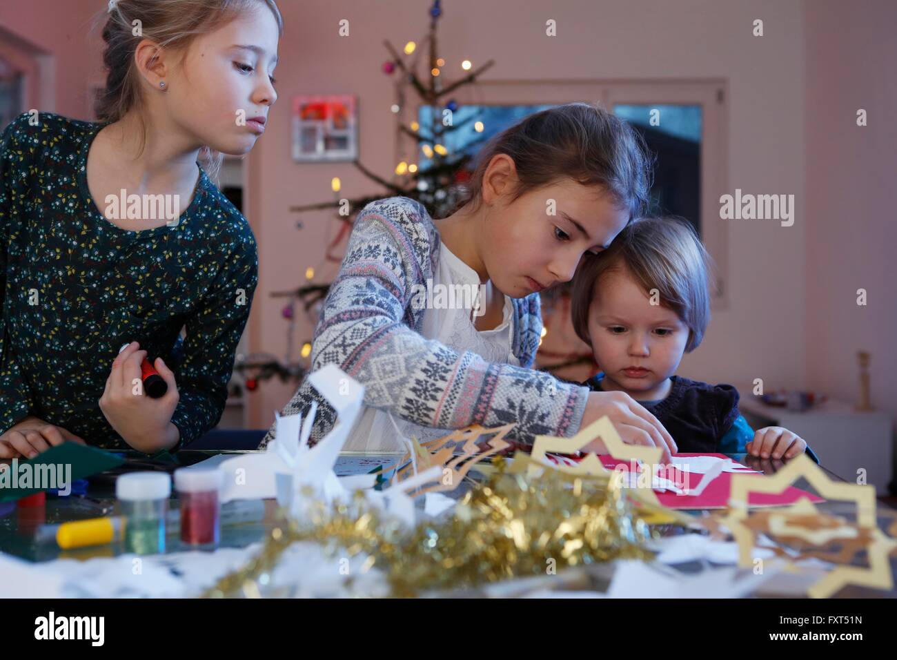 Les filles à faire de la table en papier de Noël Banque D'Images