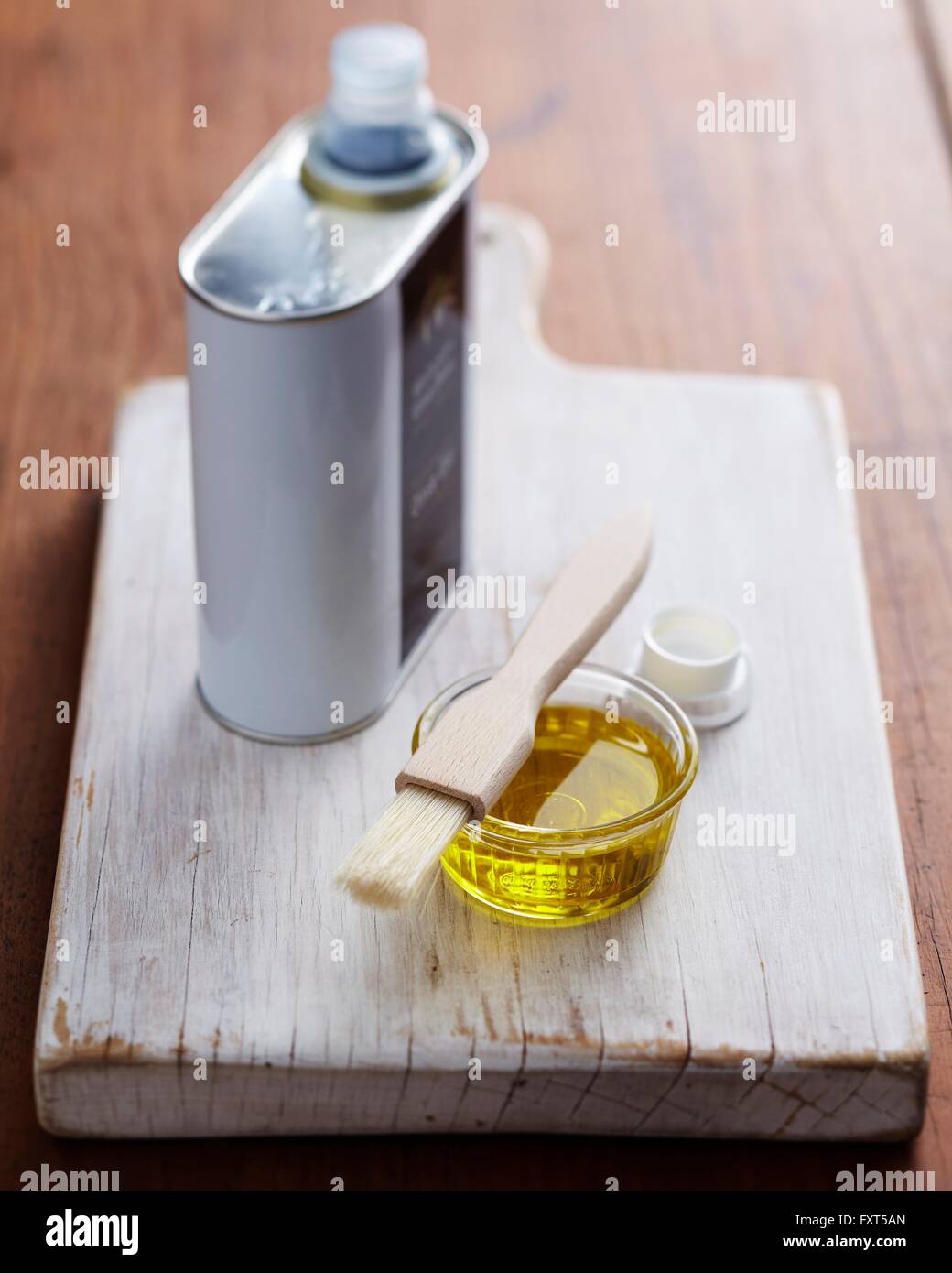 Bol de l'huile d'olive et pinceau sur planche à découper en bois Banque D'Images