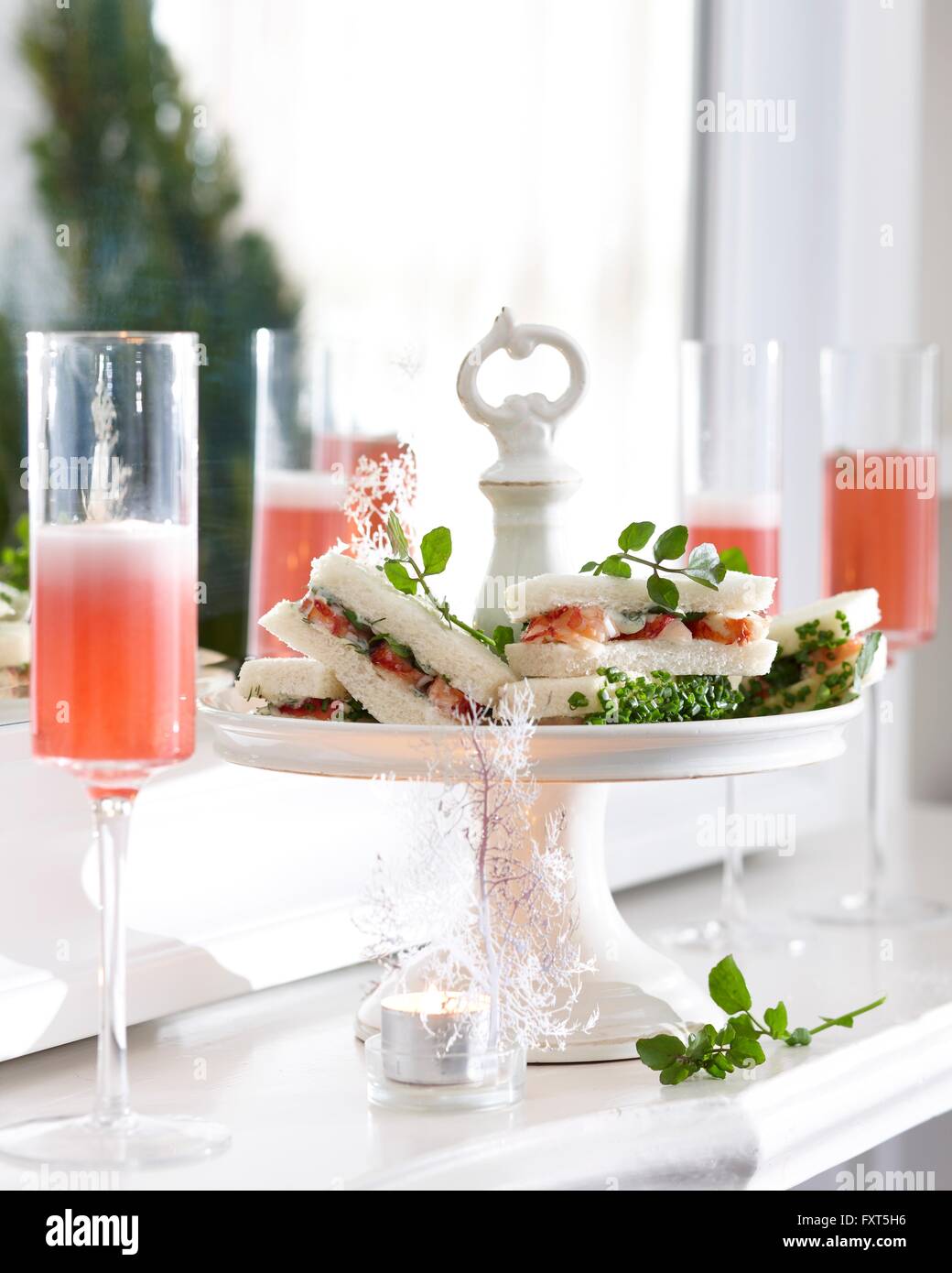 Verres de champagne rose et les écrevisses sandwiches on cake stand Banque D'Images