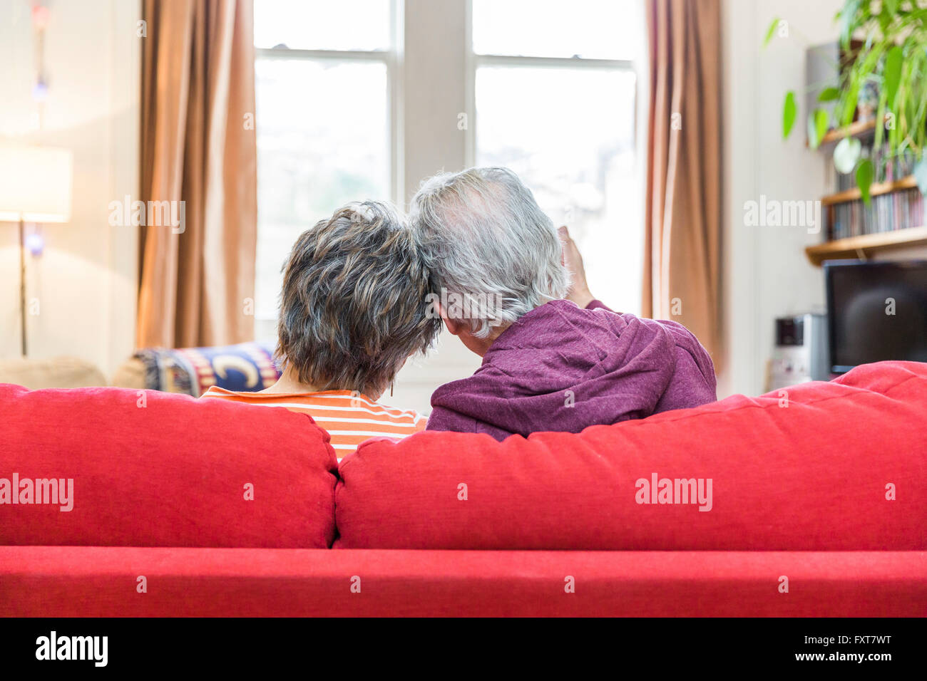 Vue arrière du romantic senior couple on sofa du salon avec ensemble Banque D'Images