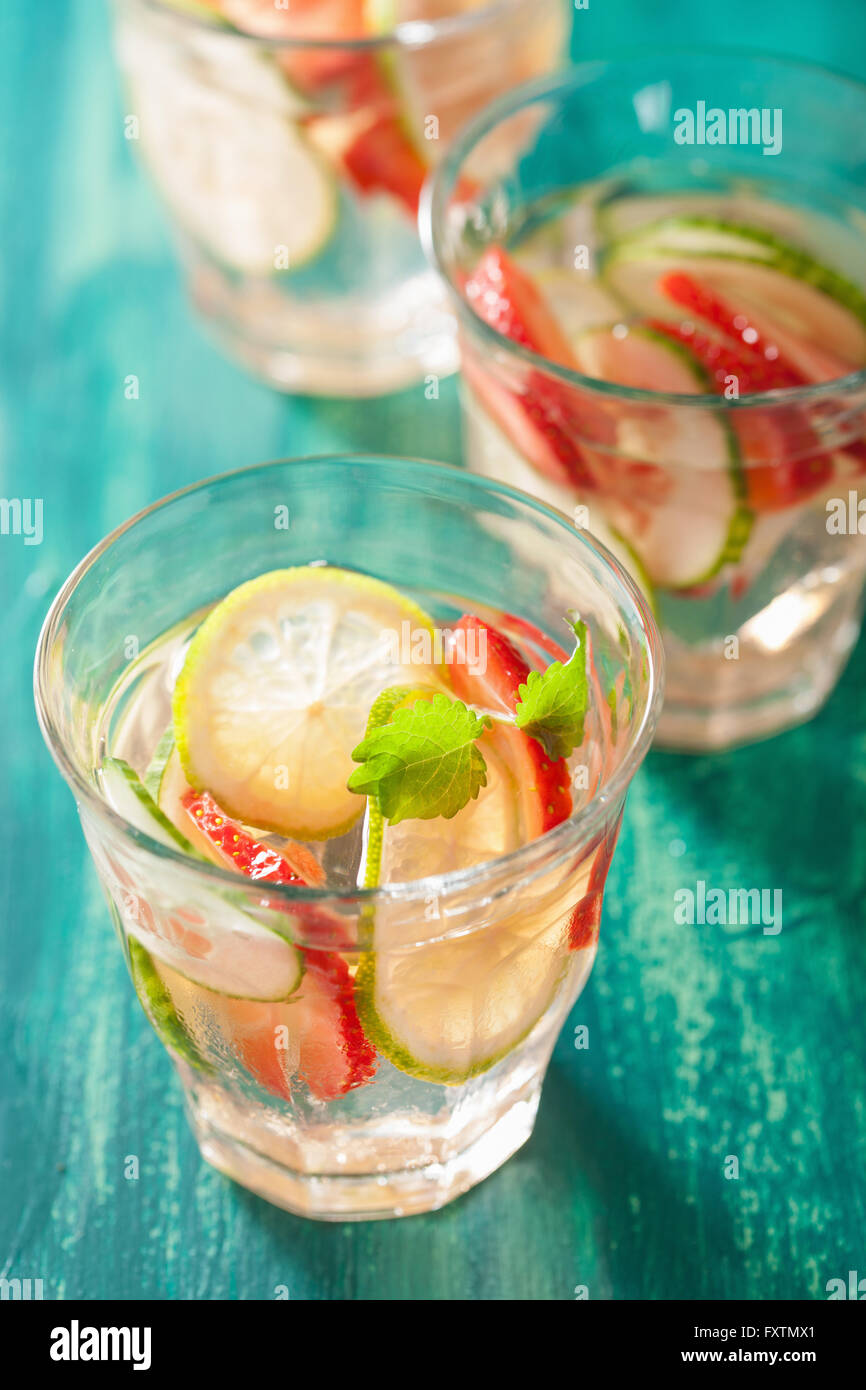 Boisson d'été rafraîchissante avec lime concombre fraises dans les verres Banque D'Images