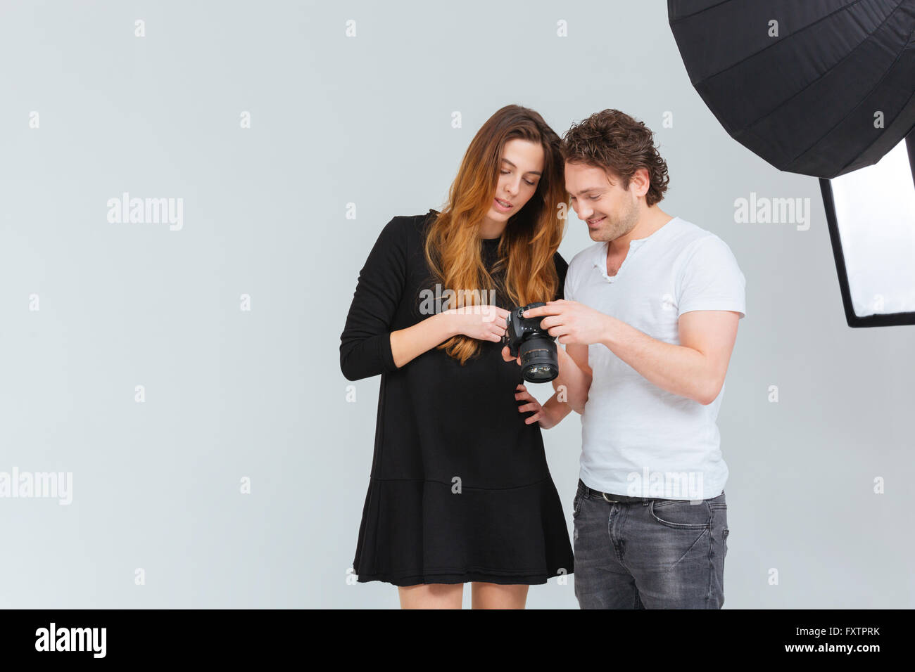 Photographe mâle avec modèle féminin à la recherche sur l'écran de l'appareil photo Banque D'Images