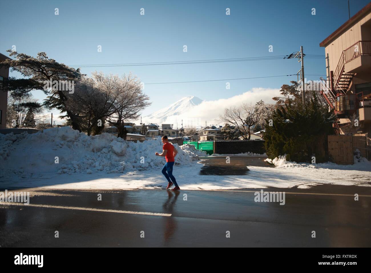 Homme mûr en marche sur la route en hiver, le lac Kawaguchiko, le Mont Fuji, Japon Banque D'Images