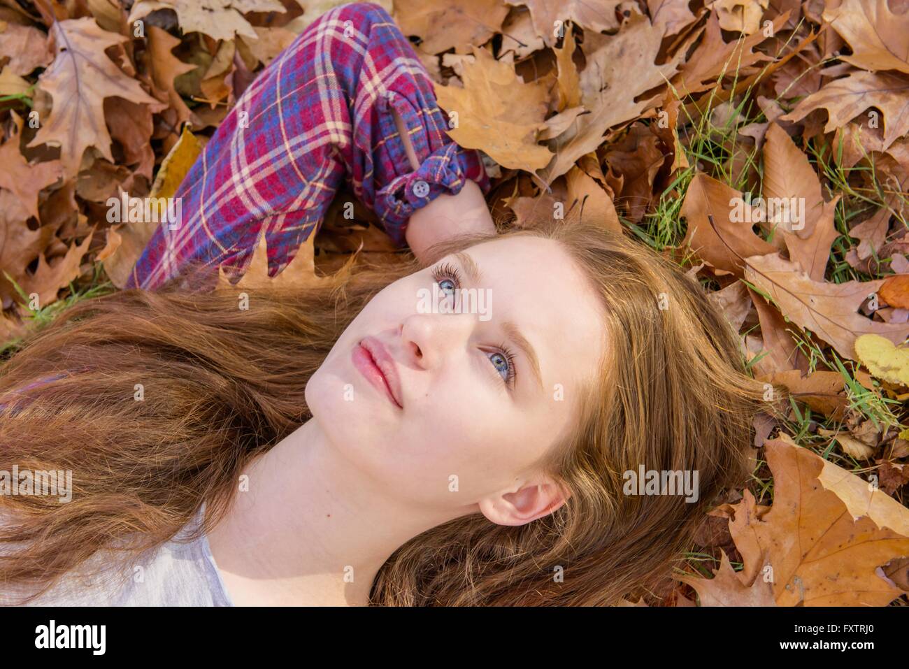 Teenage girl lying on Autumn Leaves, close-up Banque D'Images