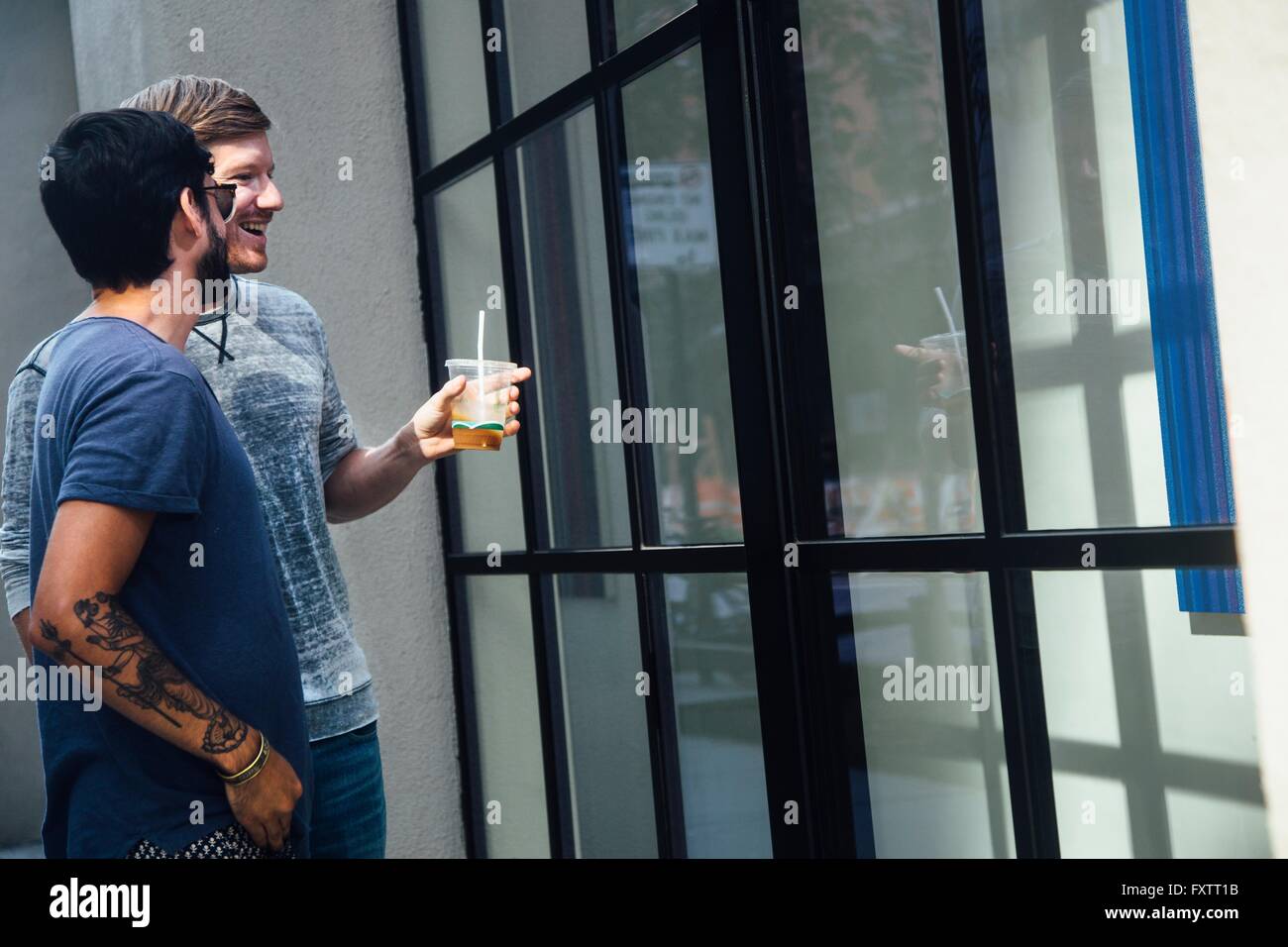 Homme couple looking at city shop window Banque D'Images