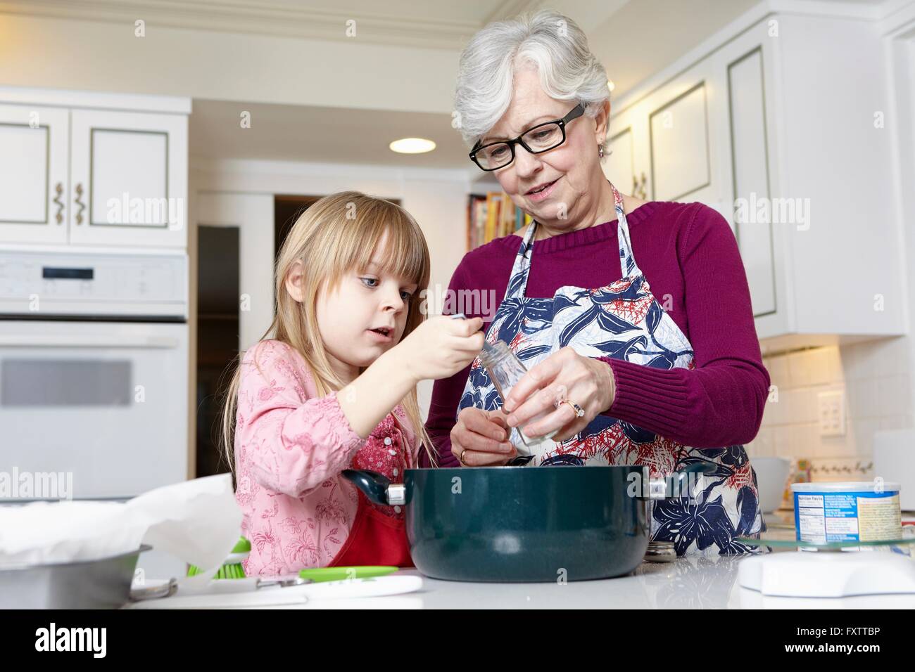 Fille et grand-mère de sel de mesure pour la cuisine Banque D'Images