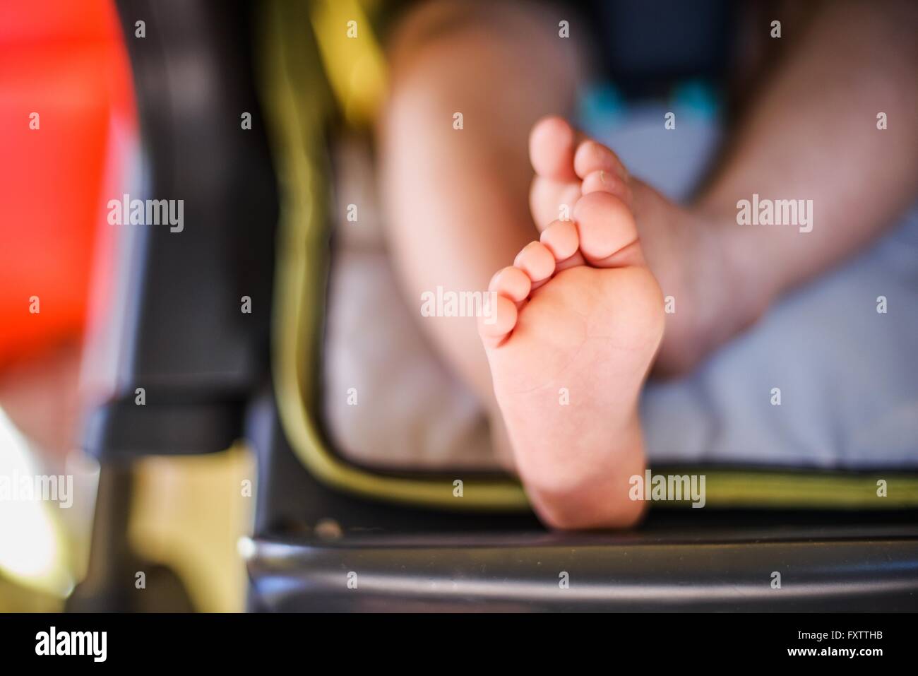 Close up of baby boys pieds assis dans une chaise haute Banque D'Images