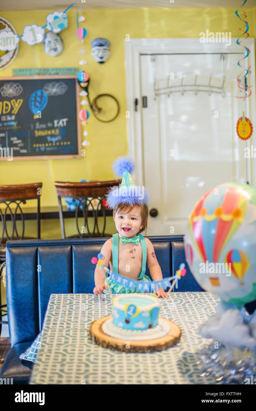 Baby Boy wearing party hat avec premier cake Banque D'Images
