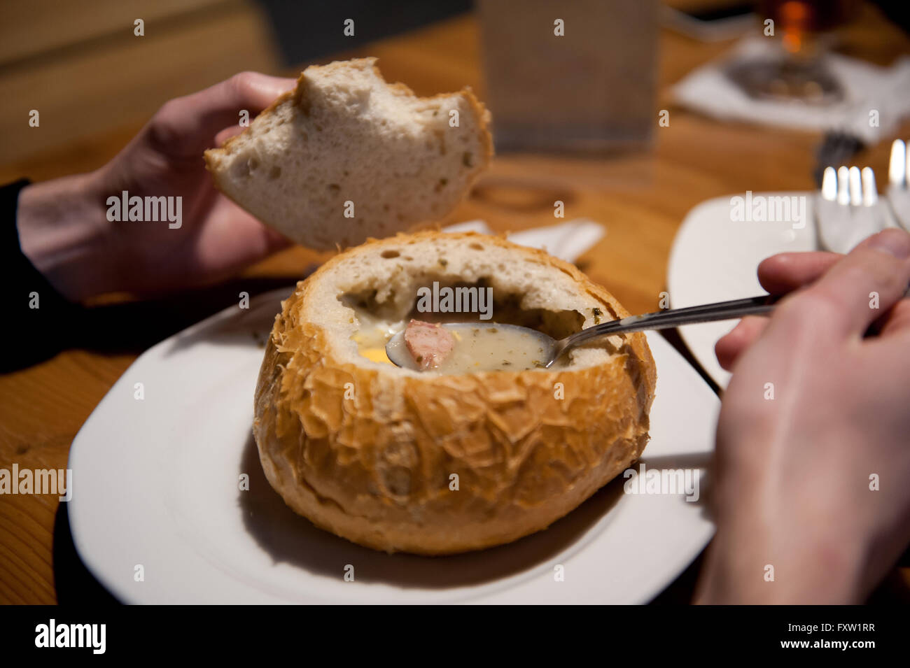 Manger du pain de seigle dans la soupe aigre avec des saucisses et des œufs, de l'alimentation sur la table au restaurant au cours de visites Pologne, traditionnel polonais Banque D'Images