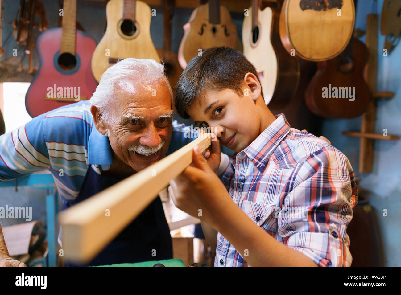 Petite entreprise familiale et traditions : vieux papi avec petit-fils de luthier shop. L'artisan principal de l'enfant apprend comment Banque D'Images